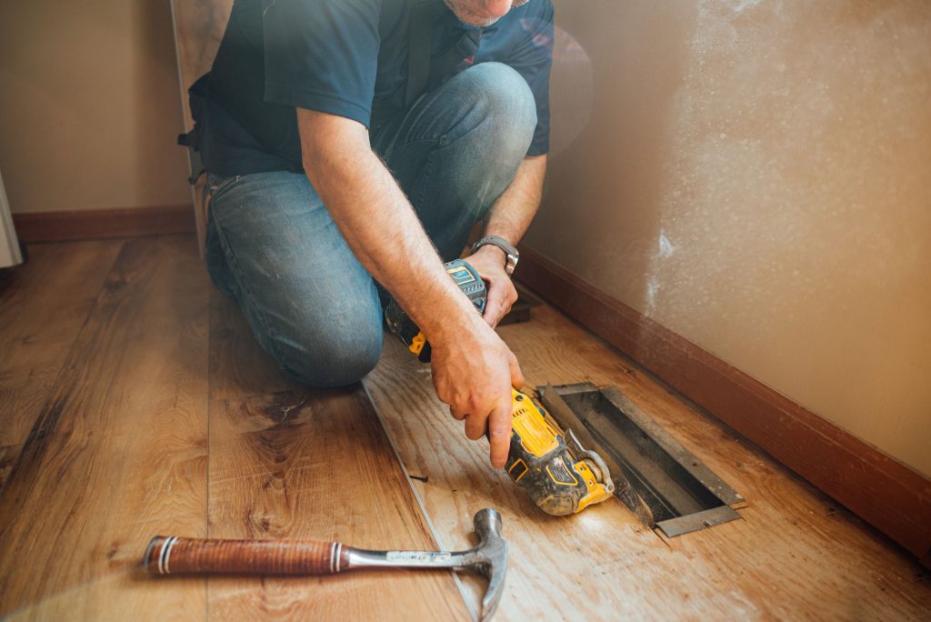 man opening heat register through floor with an royalty free image 1630022696